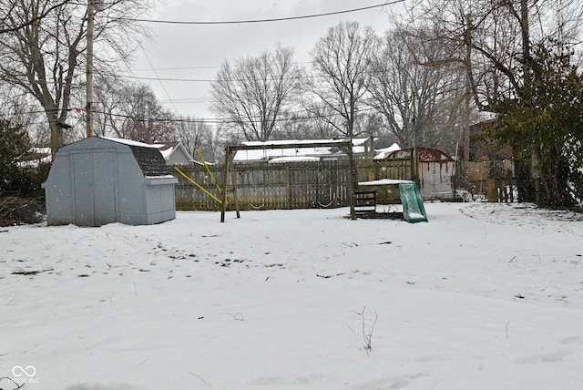 yard covered in snow featuring a shed