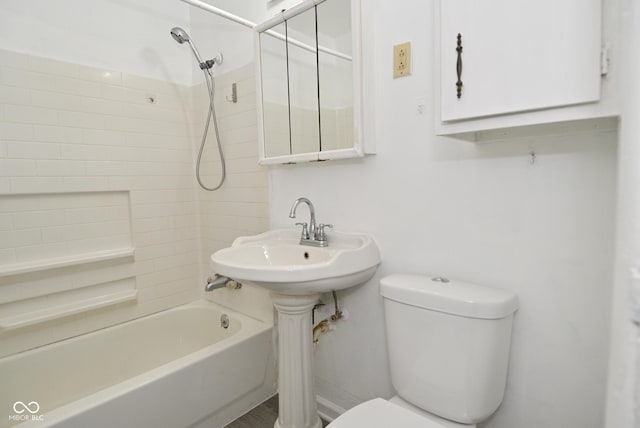 full bathroom with toilet, tiled shower / bath combo, and sink