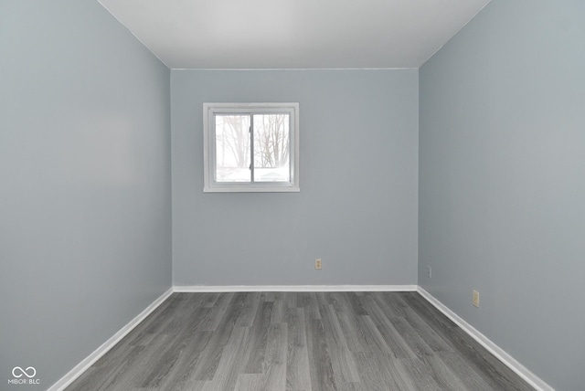 unfurnished room with baseboards and wood finished floors