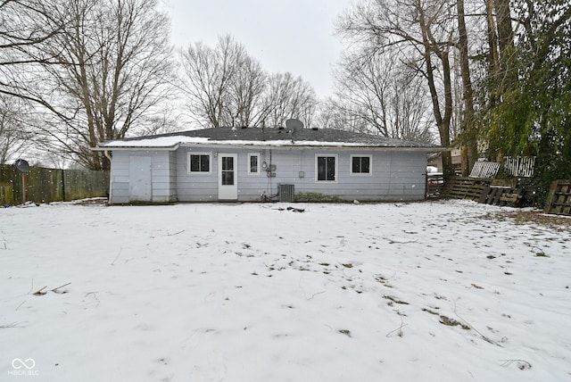 snow covered house with fence