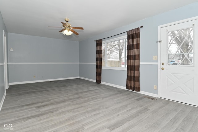 foyer entrance with wood finished floors, a ceiling fan, and baseboards