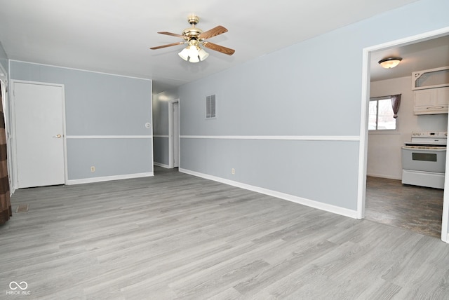 interior space with ceiling fan, light wood-style flooring, visible vents, and baseboards