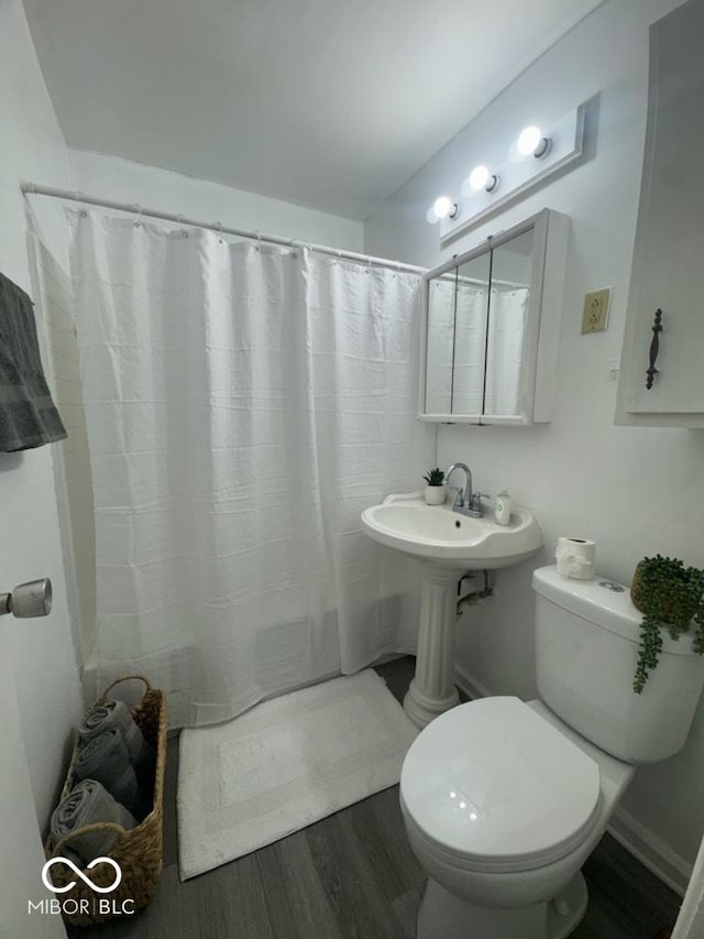 full bathroom with a shower with curtain, toilet, and wood finished floors