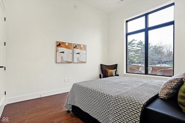 bedroom featuring multiple windows and dark hardwood / wood-style floors