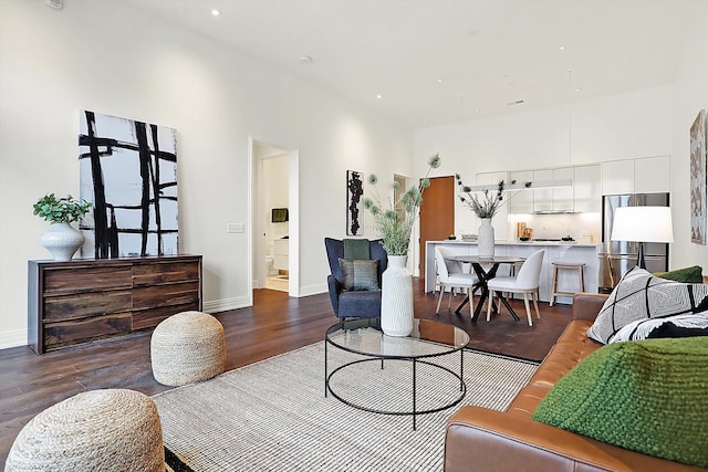 living room featuring dark hardwood / wood-style flooring and a high ceiling