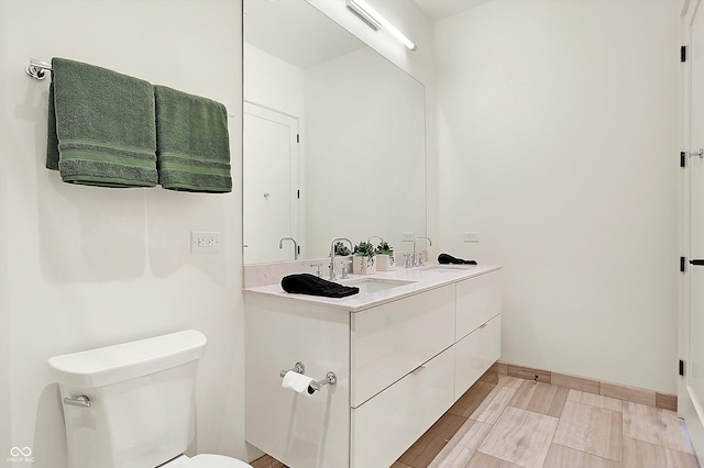 bathroom with hardwood / wood-style flooring, vanity, and toilet