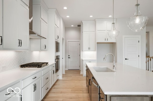 kitchen with white cabinetry, a kitchen island with sink, pendant lighting, and appliances with stainless steel finishes