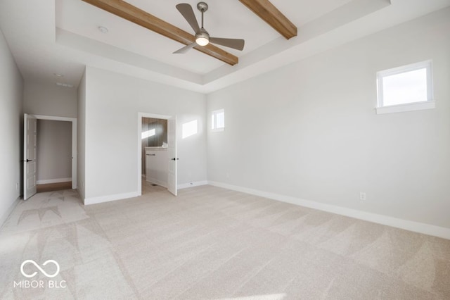 unfurnished bedroom featuring a raised ceiling, ceiling fan, light colored carpet, and beam ceiling