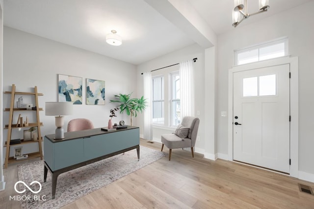 entrance foyer with light hardwood / wood-style floors and an inviting chandelier