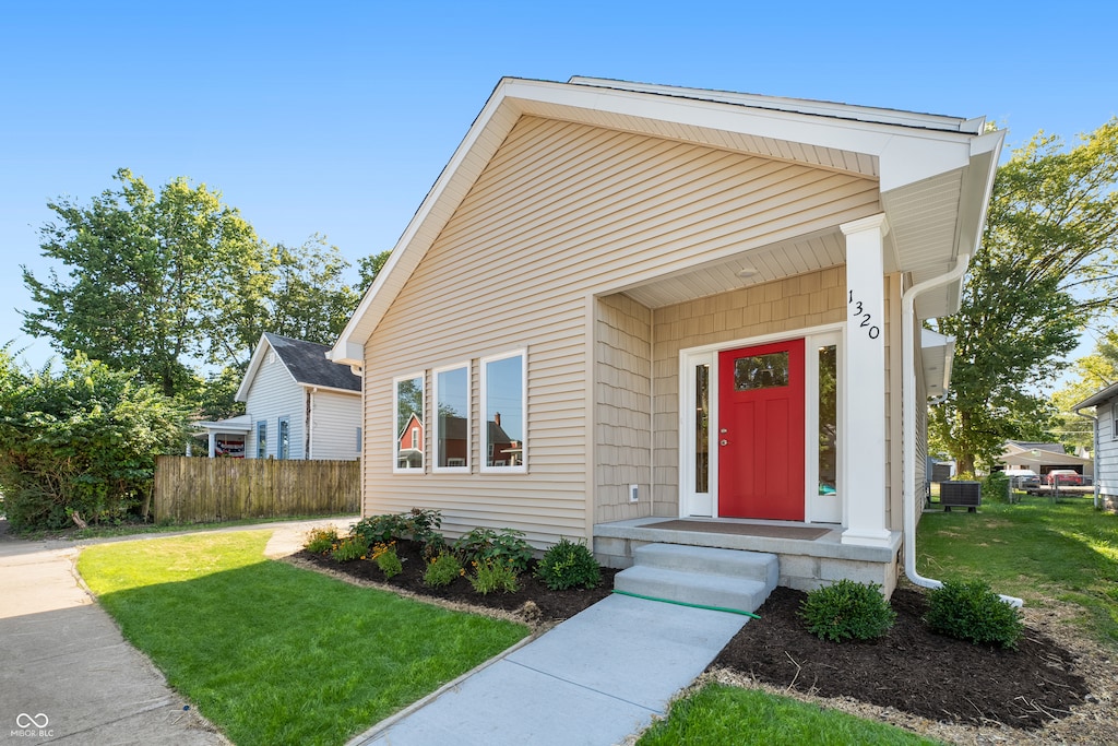 view of front of property featuring a front lawn and central AC unit