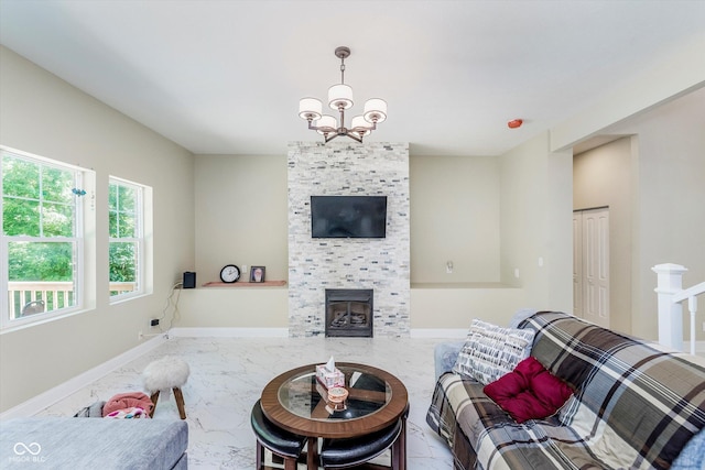 living room featuring a tiled fireplace and an inviting chandelier