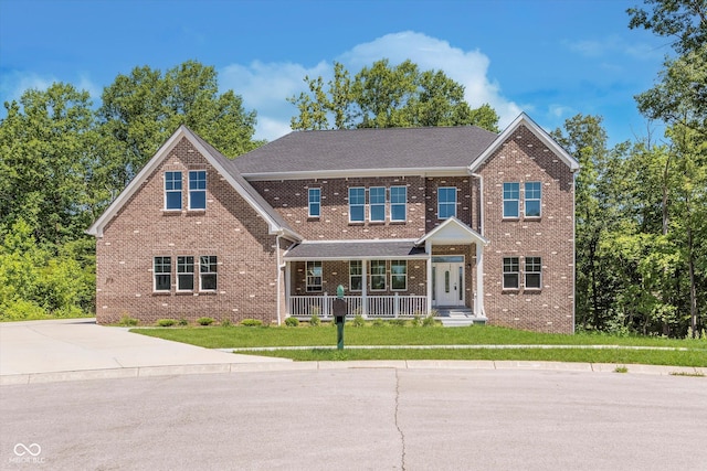 view of front of property featuring covered porch and a front lawn