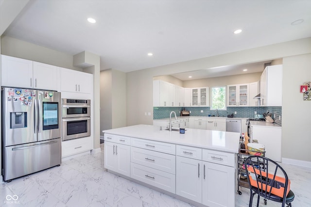 kitchen featuring backsplash, stainless steel appliances, sink, and white cabinets