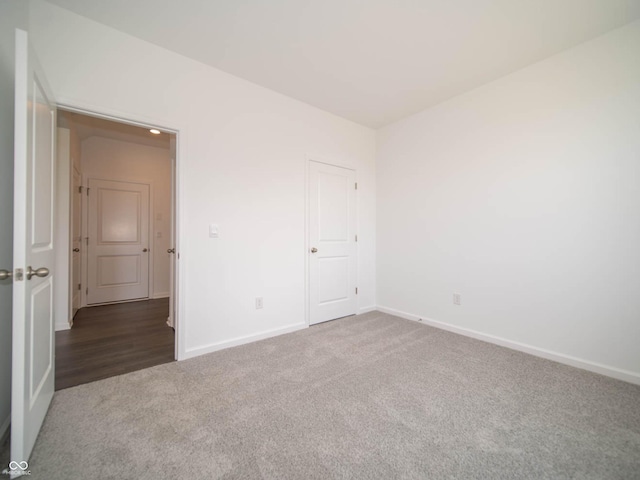 unfurnished room featuring dark carpet