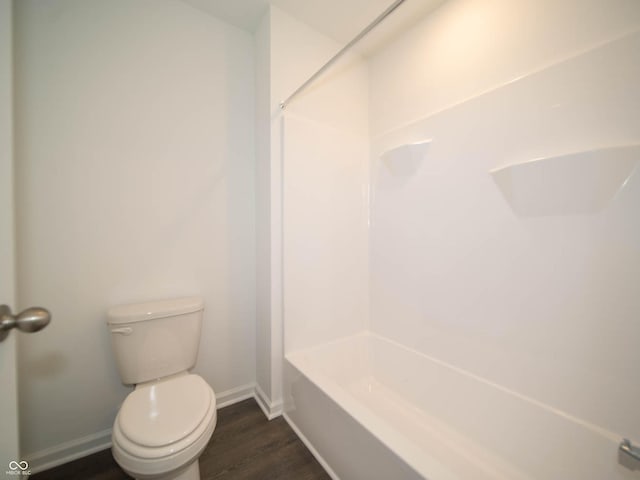 bathroom featuring hardwood / wood-style floors, bathing tub / shower combination, and toilet