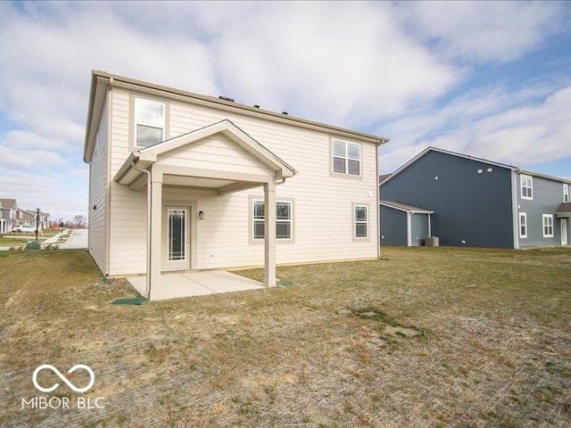 rear view of property with a lawn and a patio area