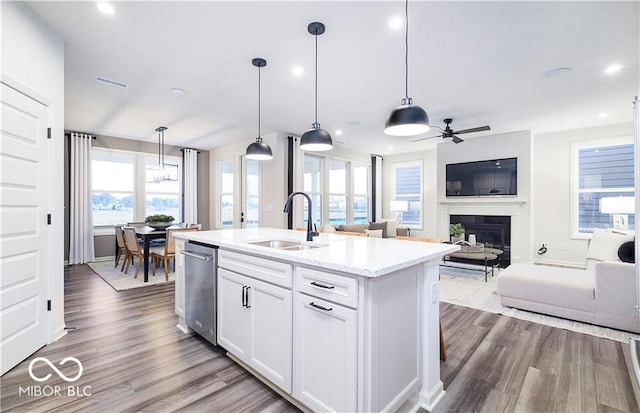 kitchen with pendant lighting, a center island with sink, white cabinets, ceiling fan, and sink