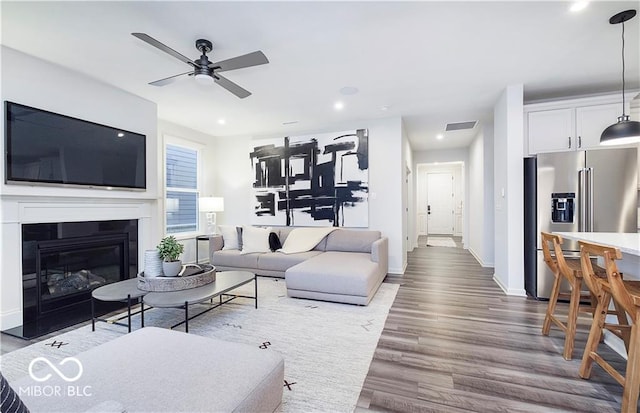 living room with ceiling fan and wood-type flooring