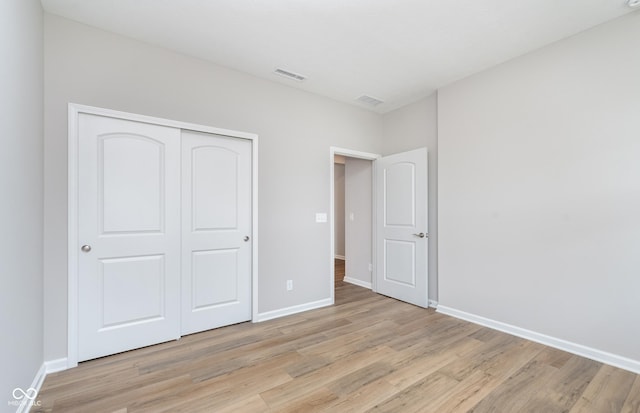 unfurnished bedroom featuring light hardwood / wood-style floors and a closet