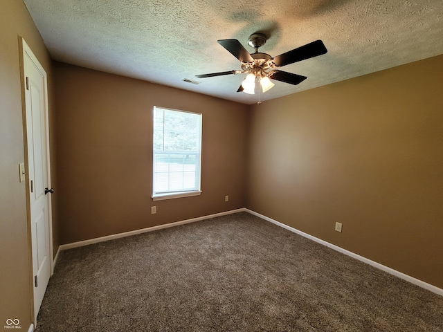 spare room with ceiling fan, dark carpet, and a textured ceiling