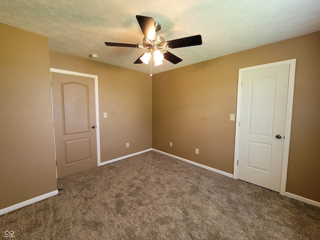 carpeted spare room with ceiling fan and a textured ceiling