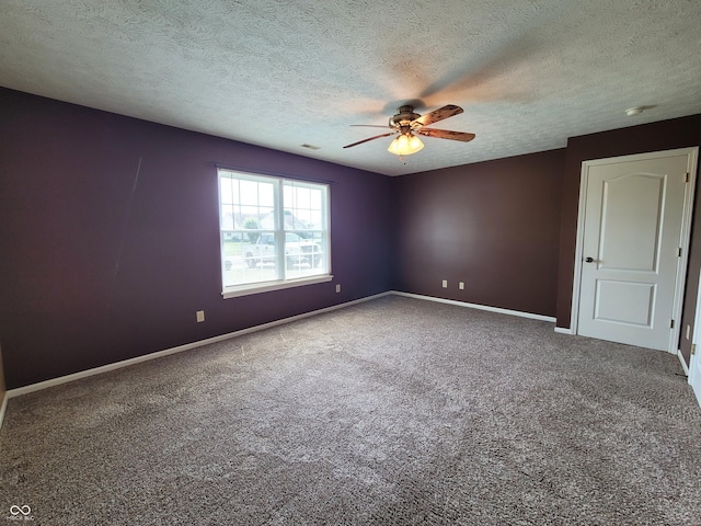 carpeted empty room with ceiling fan and a textured ceiling