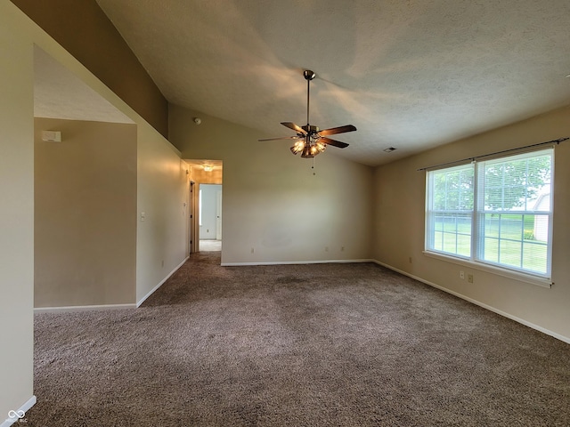 carpeted spare room featuring ceiling fan, lofted ceiling, and a textured ceiling