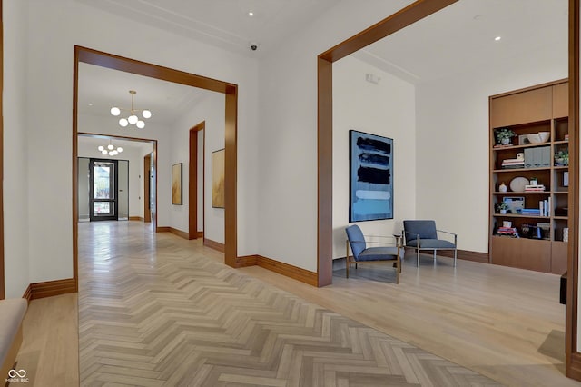 hallway featuring light parquet floors and a notable chandelier