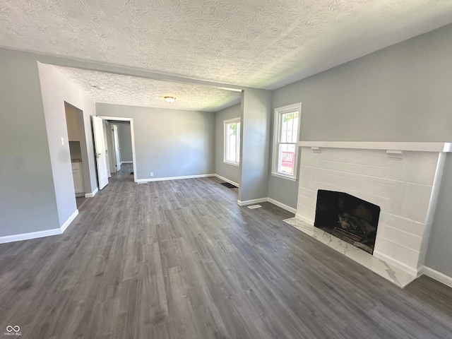 unfurnished living room featuring dark hardwood / wood-style floors and a textured ceiling