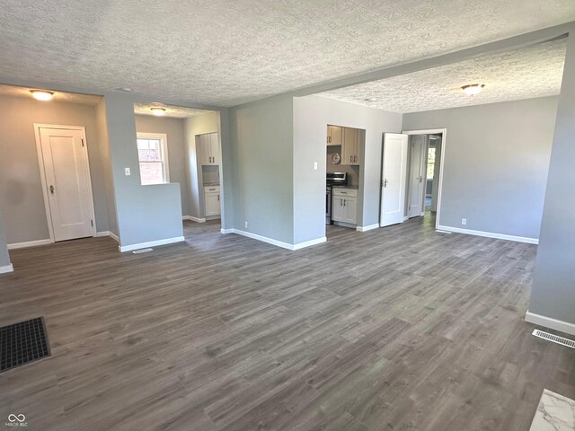 unfurnished living room featuring wood-type flooring and a textured ceiling