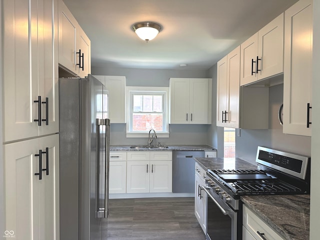 kitchen featuring dark stone countertops, sink, white cabinets, and appliances with stainless steel finishes