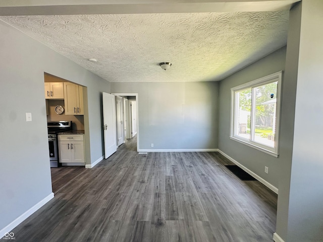 unfurnished living room featuring a textured ceiling and dark hardwood / wood-style floors