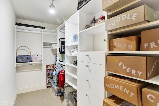 walk in closet with light colored carpet