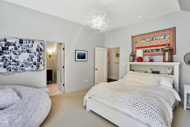 bedroom featuring light carpet, ensuite bathroom, vaulted ceiling, and a chandelier