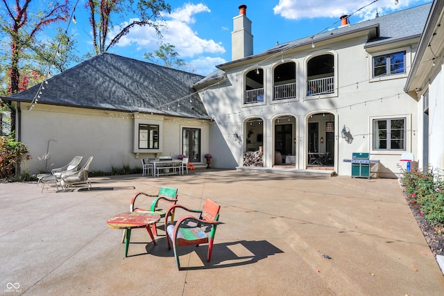 rear view of house with a balcony and a patio area