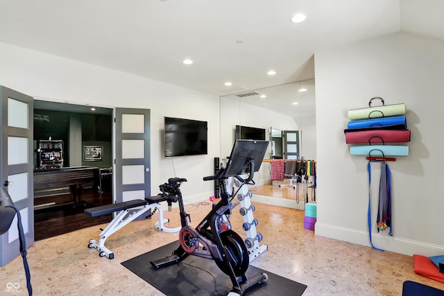 exercise area featuring hardwood / wood-style floors and vaulted ceiling