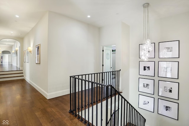 corridor featuring dark hardwood / wood-style floors and a chandelier