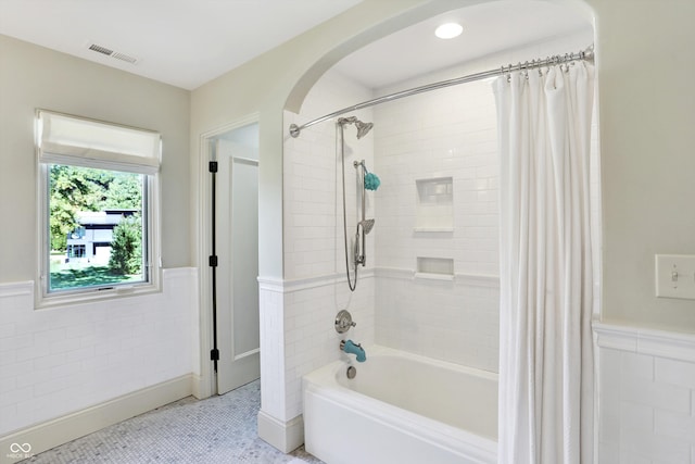 bathroom featuring tile patterned flooring, shower / tub combo with curtain, and tile walls