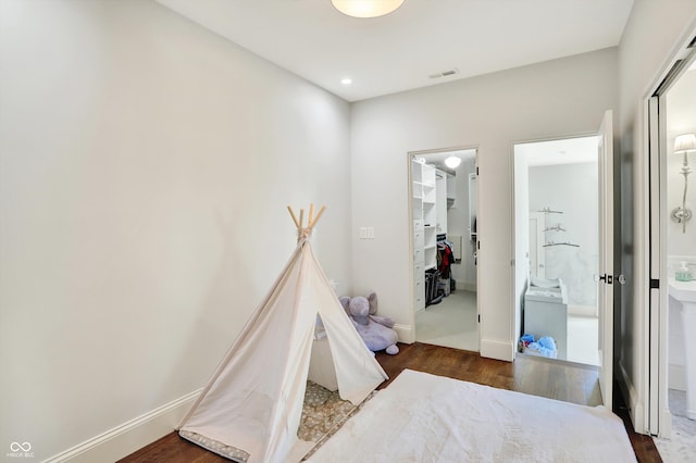 bedroom featuring a closet, dark hardwood / wood-style floors, and a walk in closet