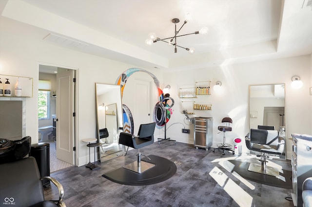 workout room with a raised ceiling, dark hardwood / wood-style floors, and a chandelier