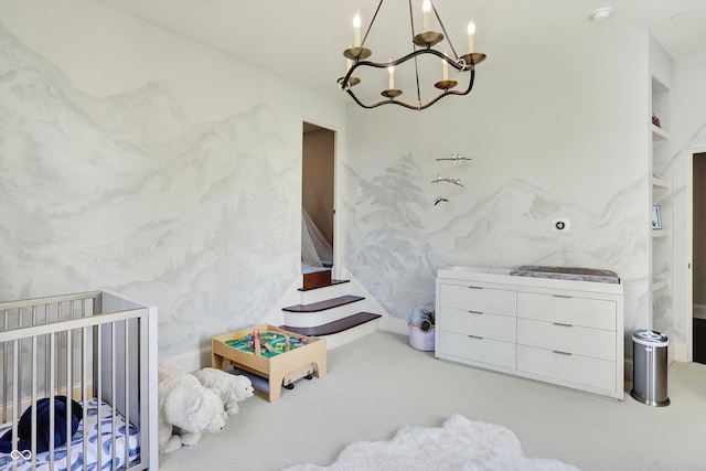 bedroom with a crib and an inviting chandelier