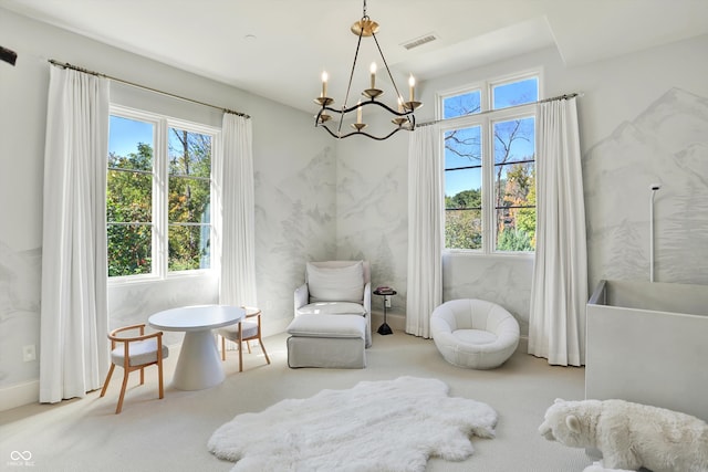 living area with carpet and an inviting chandelier