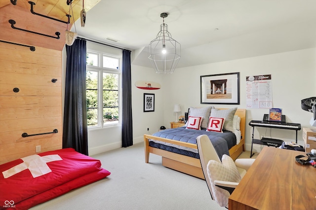 bedroom featuring light colored carpet and wood walls