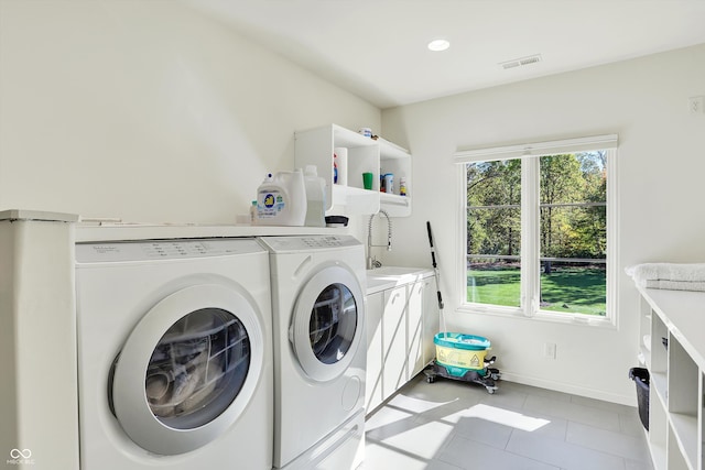 washroom with sink, light tile patterned floors, and washing machine and dryer