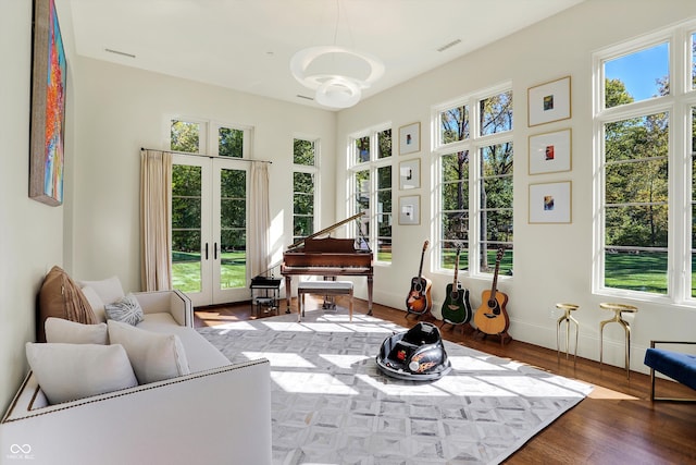 sunroom / solarium featuring a healthy amount of sunlight and french doors