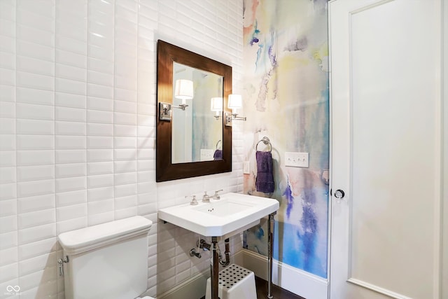 bathroom with tile walls and toilet