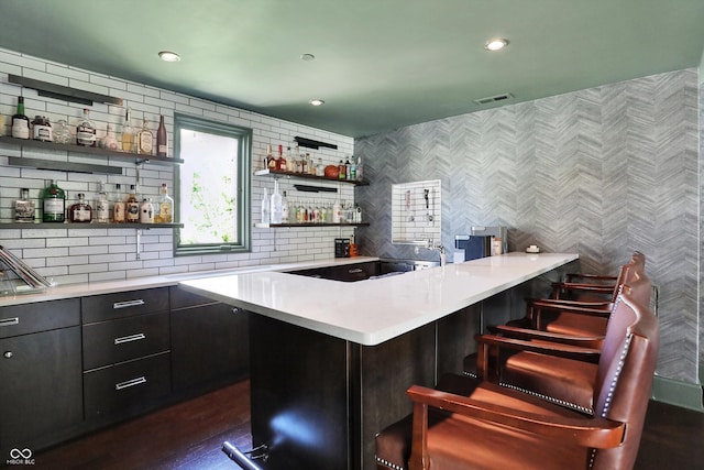 bar featuring dark wood-type flooring and decorative backsplash