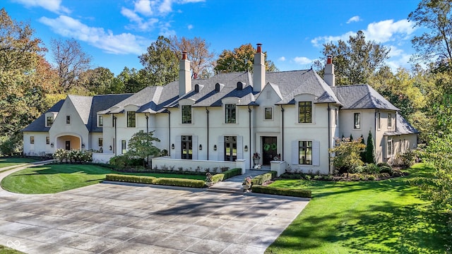 french provincial home with a front lawn