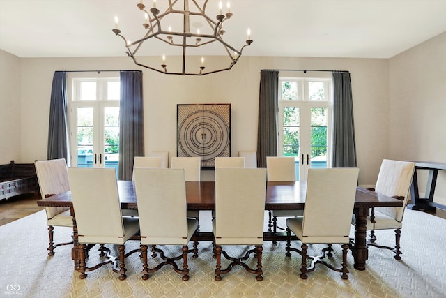 dining room featuring plenty of natural light, french doors, hardwood / wood-style floors, and an inviting chandelier