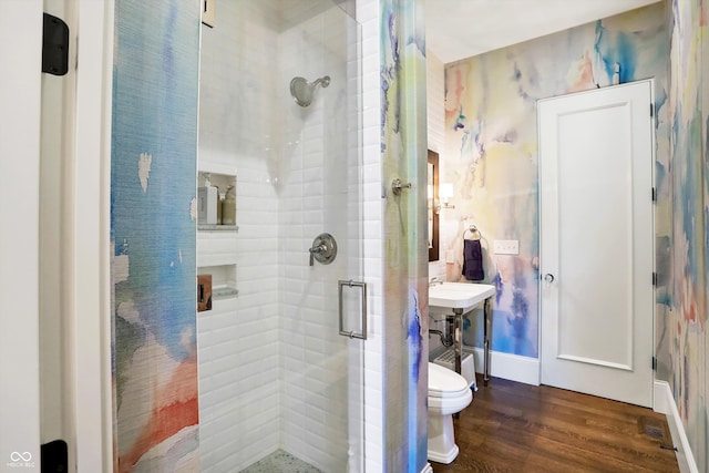 bathroom with hardwood / wood-style floors, toilet, and a shower with shower door